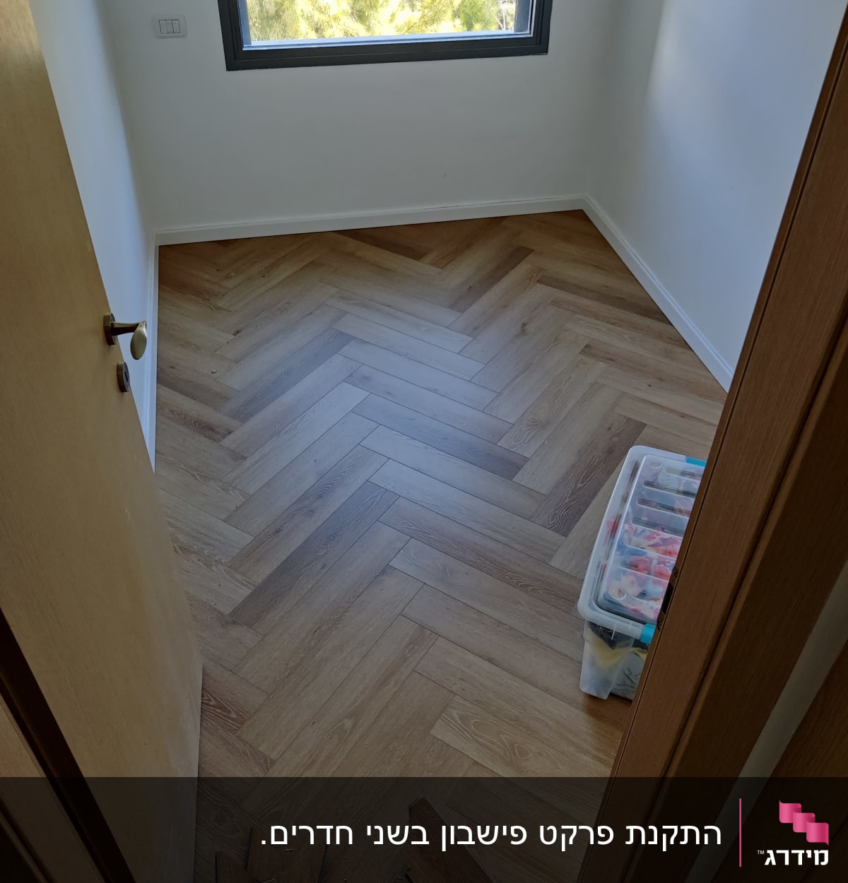 רצפת פרקט עץ בהתקנה בחדר קטן עם חלון